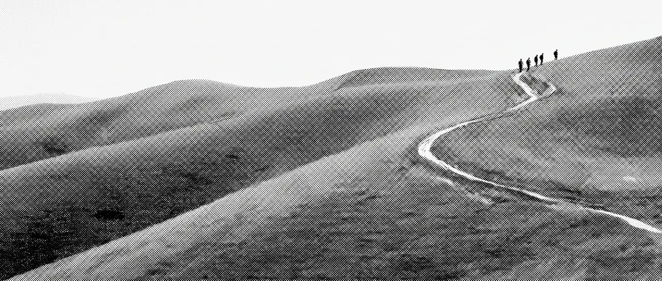 A hill road walked by a distant group of people