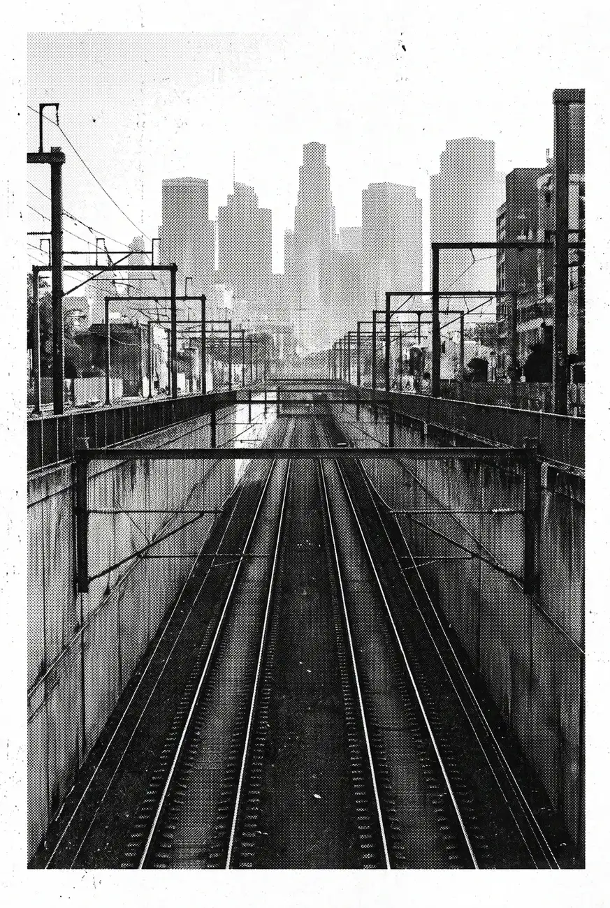 Railway tracks running towards a city, in black and white